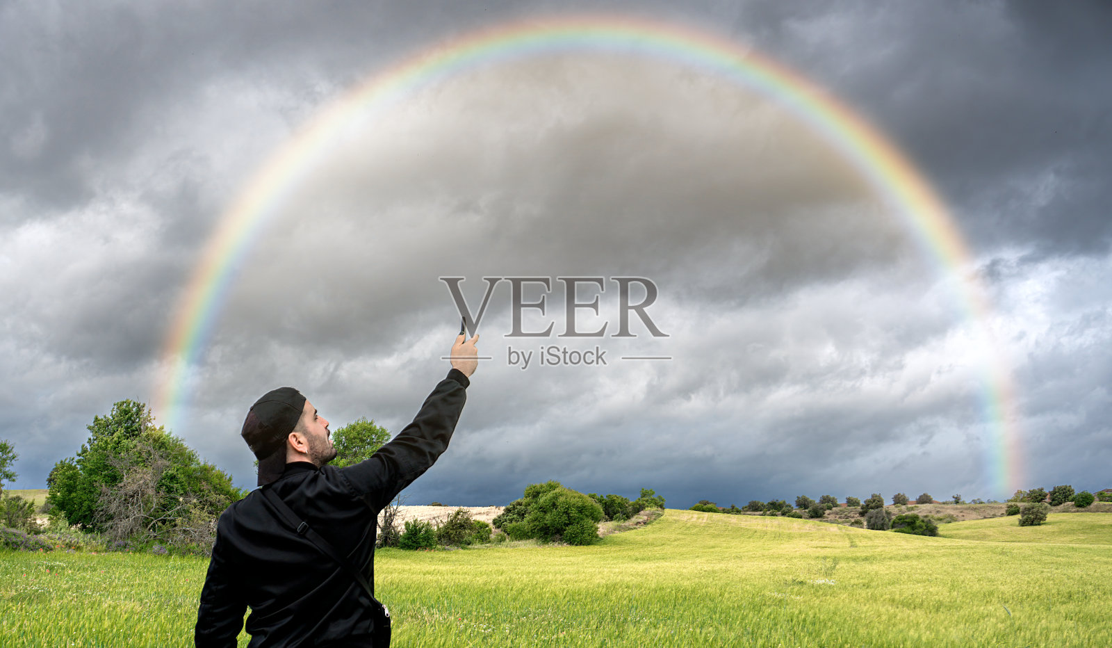 一名男子将智能手机举向天空，试图接收手机信号照片摄影图片