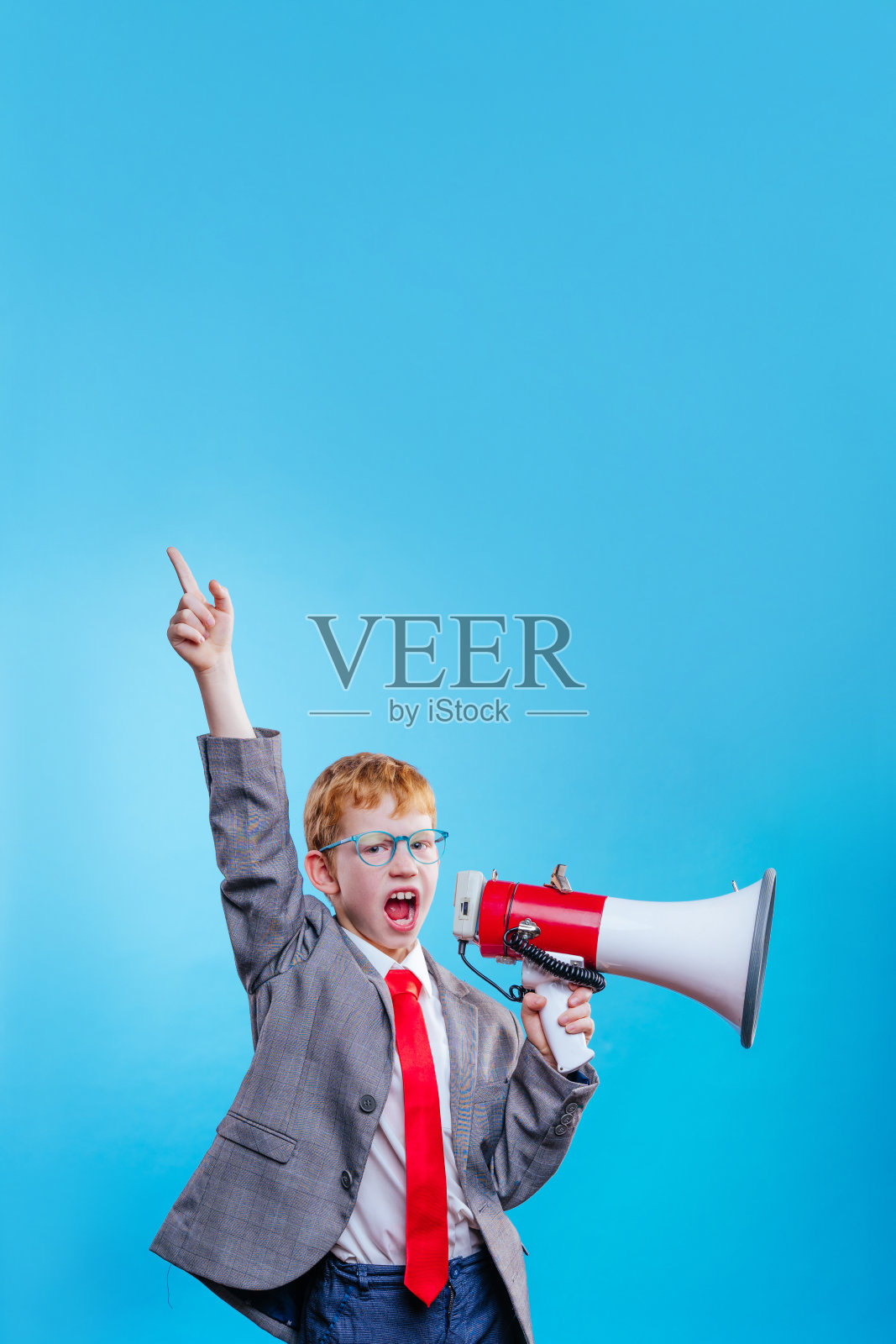 有趣的红头发男孩年轻的商人与眼镜在蓝色的背景照片摄影图片