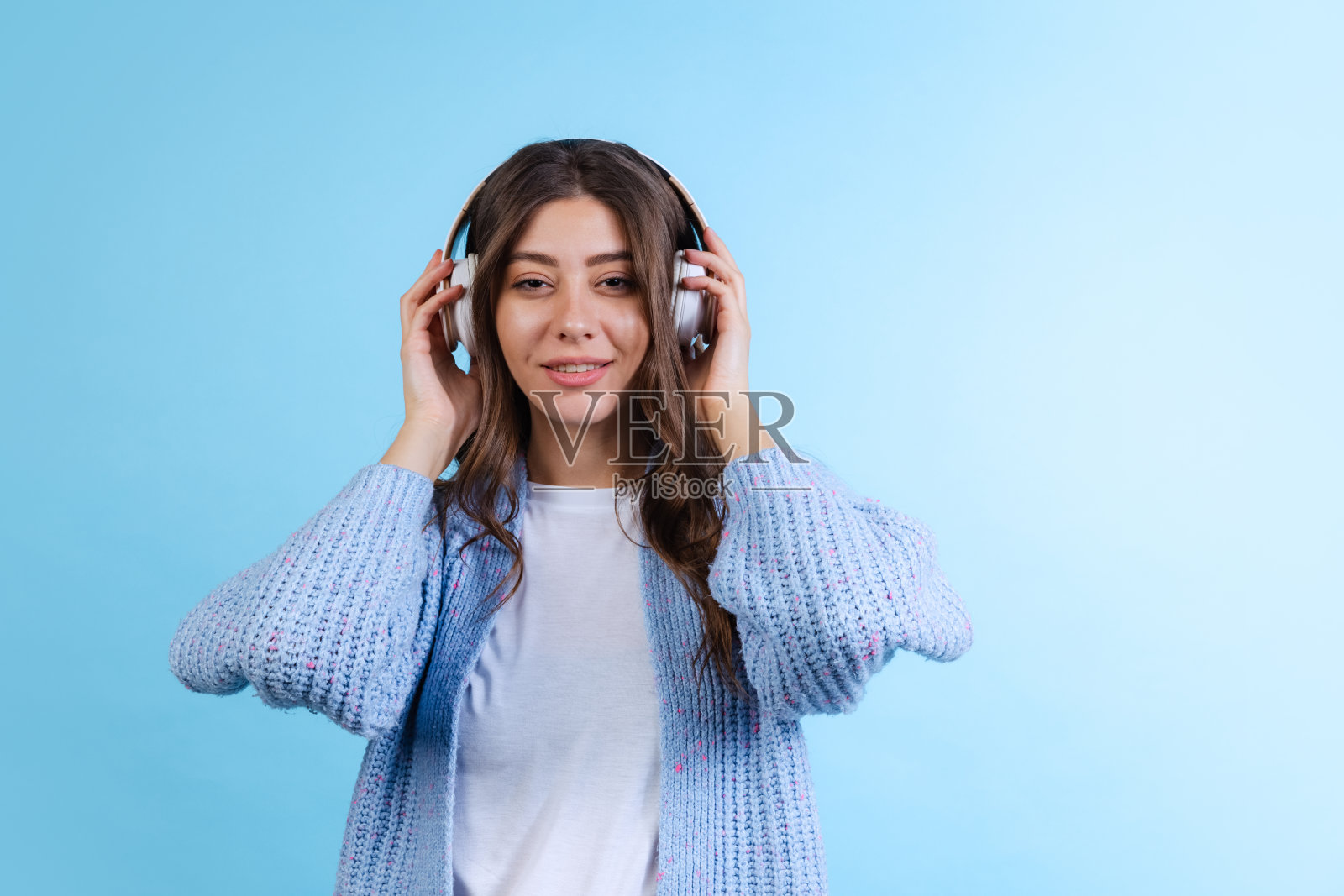 半长肖像年轻美丽的女孩听音乐孤立在海军蓝工作室背景在霓虹灯。照片摄影图片