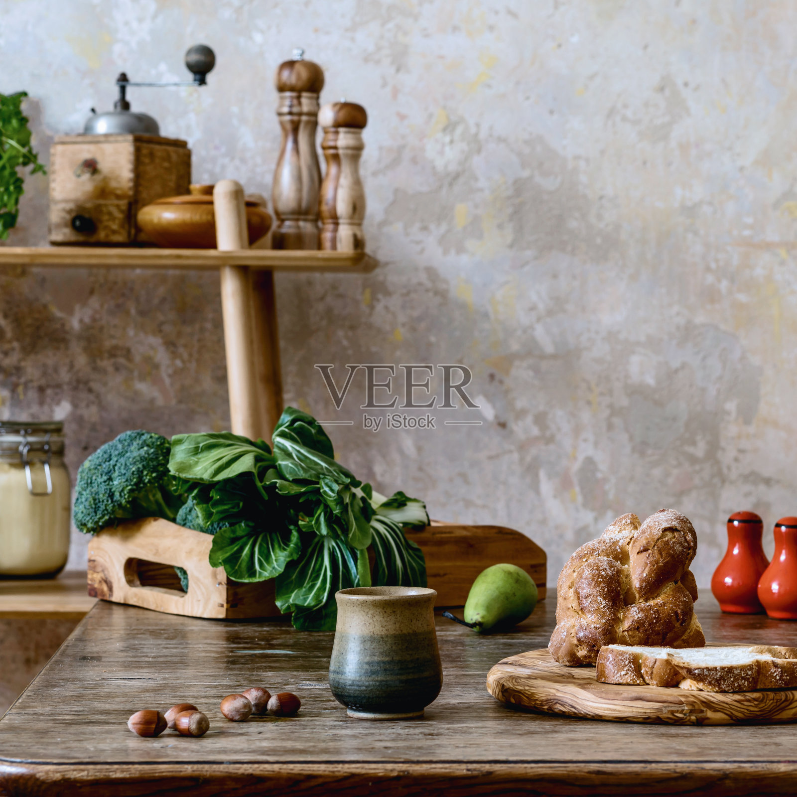 时尚的厨房内部组成木制模型框架，家庭餐桌，梯子，蔬菜，茶壶，甜点和厨房配件。侘寂家居装饰理念。国家的一面。模板。照片摄影图片