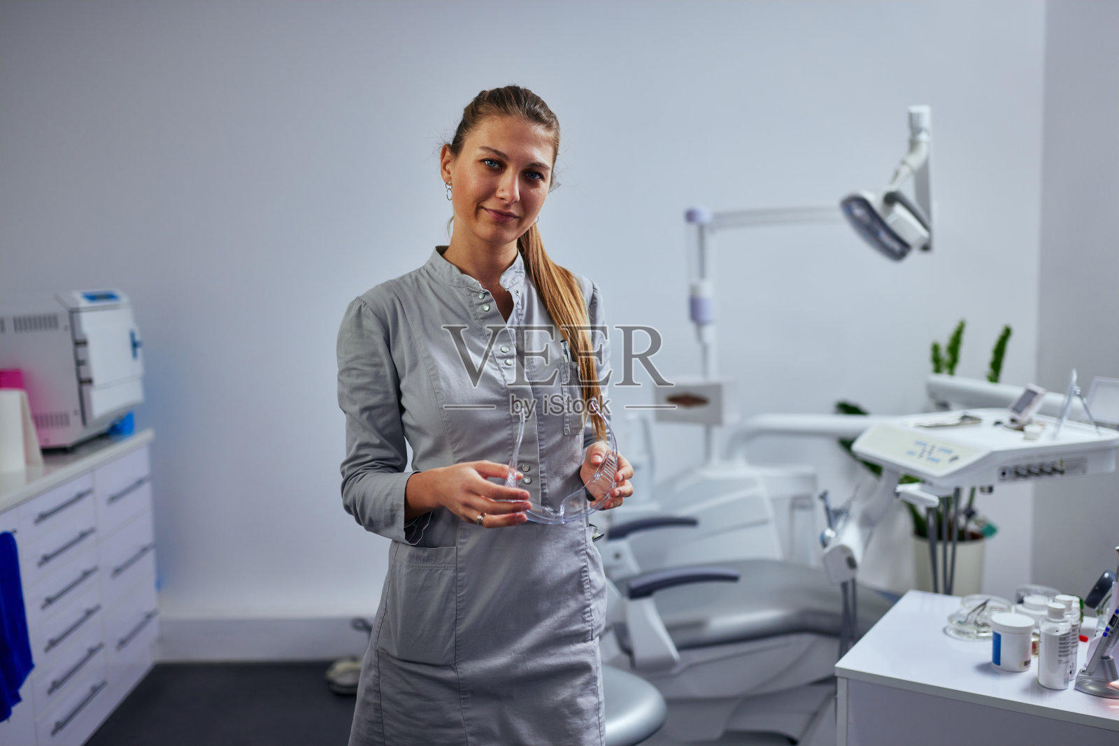 有经验的女牙医站在她的办公室里照片摄影图片