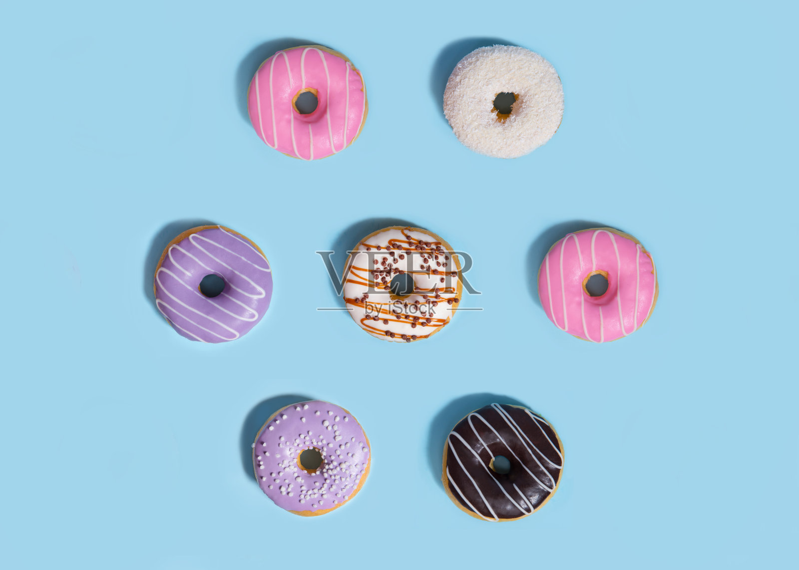 甜甜圈在蓝色的桌子背景。照片摄影图片