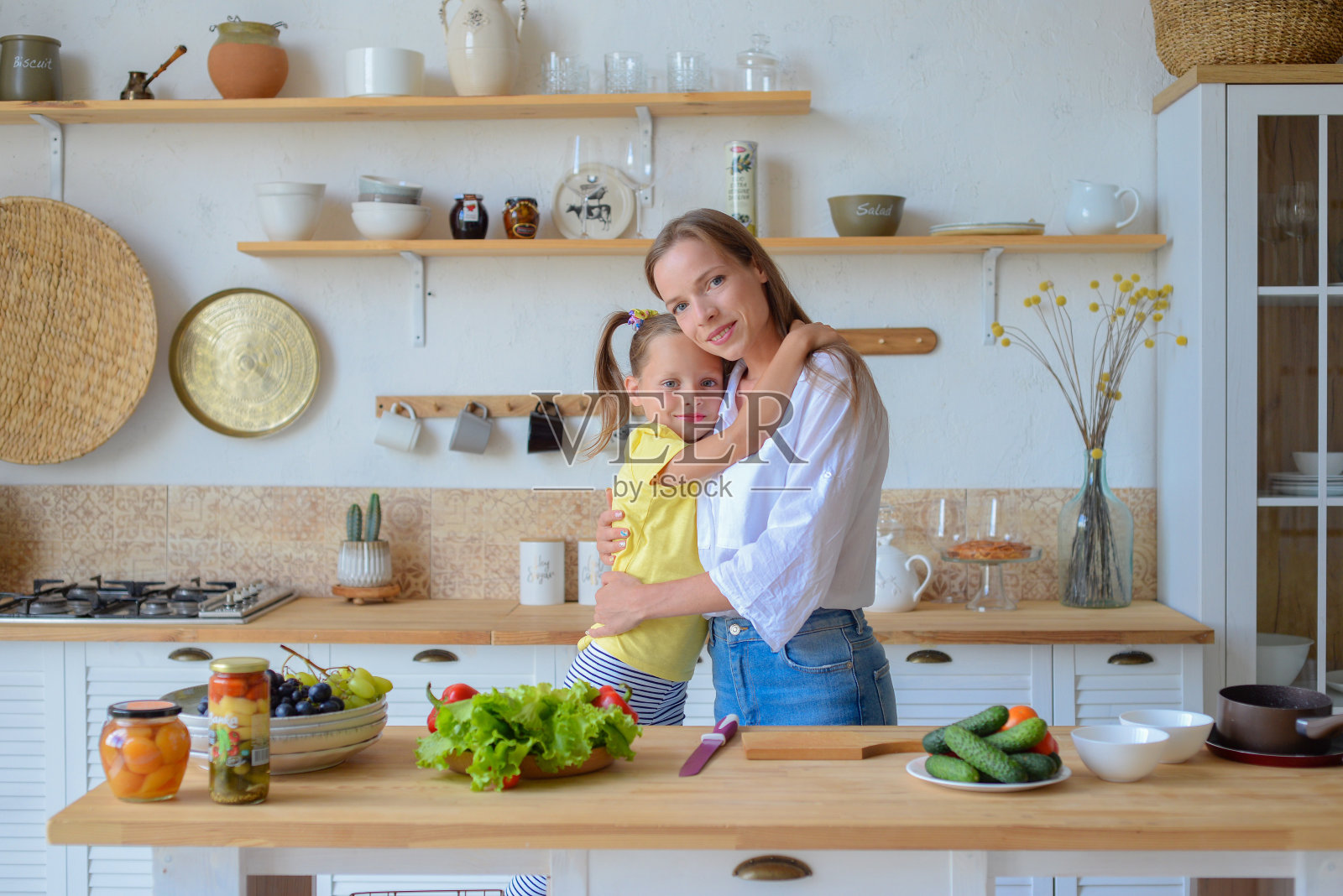 妈妈和小女儿正在厨房里准备健康的食物。素食主义。饮食。健康的生活方式照片摄影图片