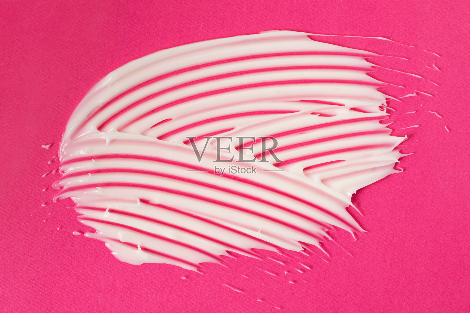 粉色背景上的白色奶油。照片摄影图片