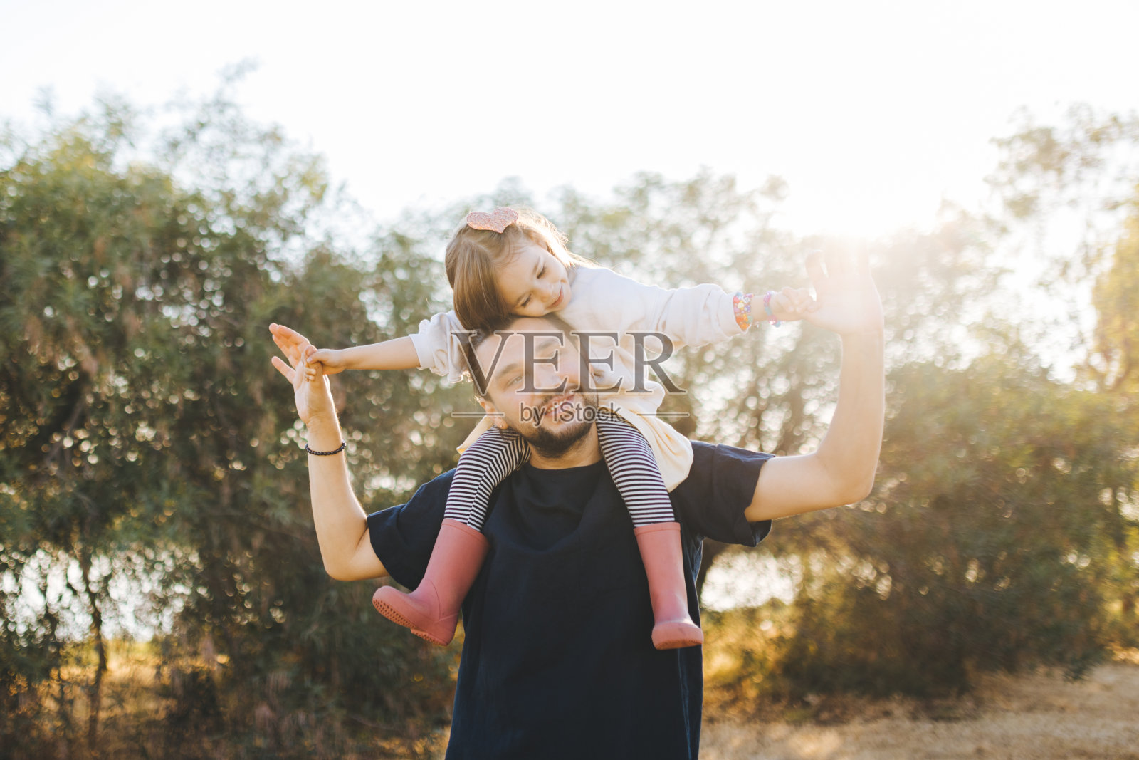年轻的父亲在大自然中扛着女儿照片摄影图片