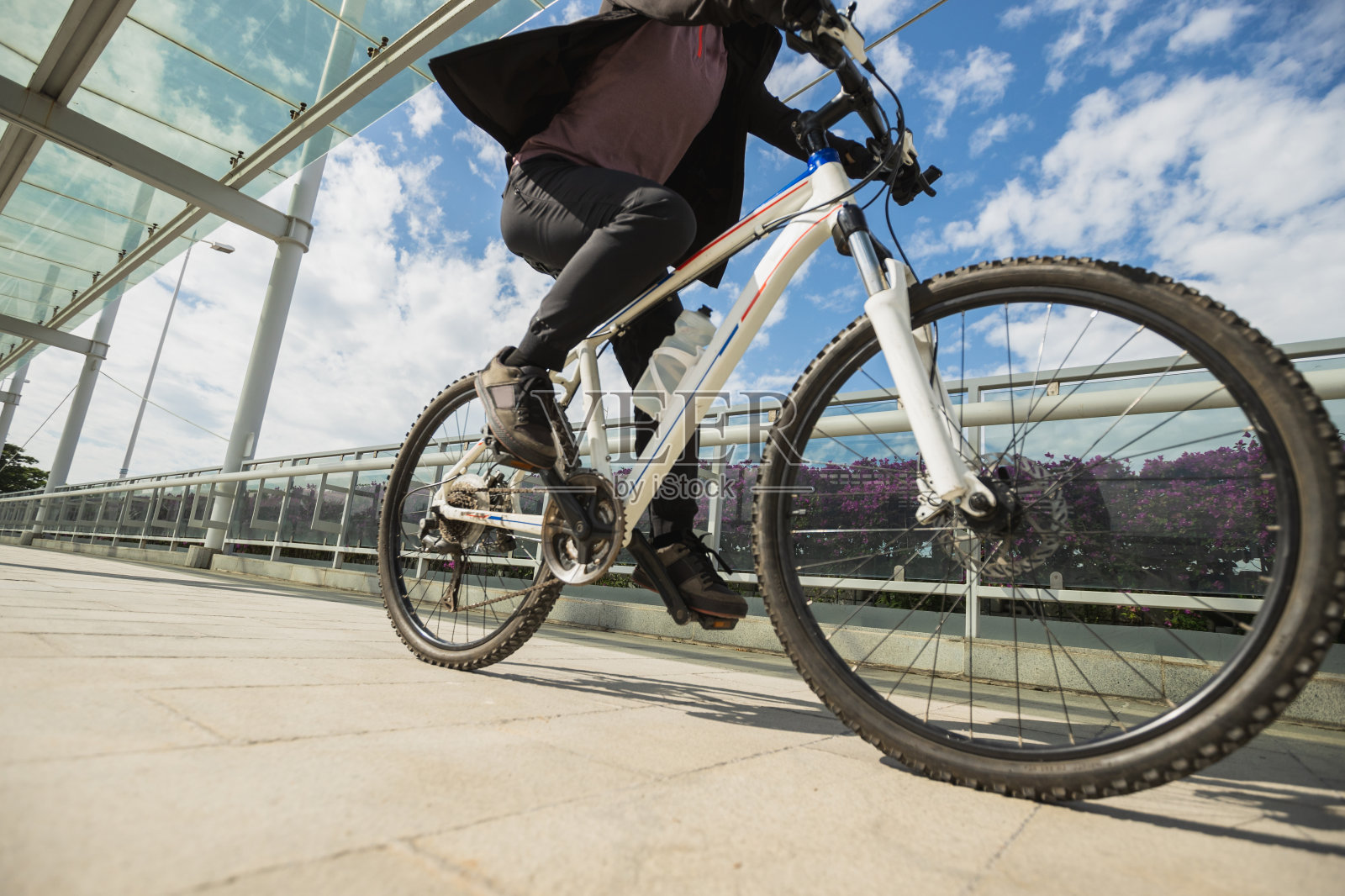 在一个阳光明媚的日子里，一个女人在城市里骑自行车照片摄影图片