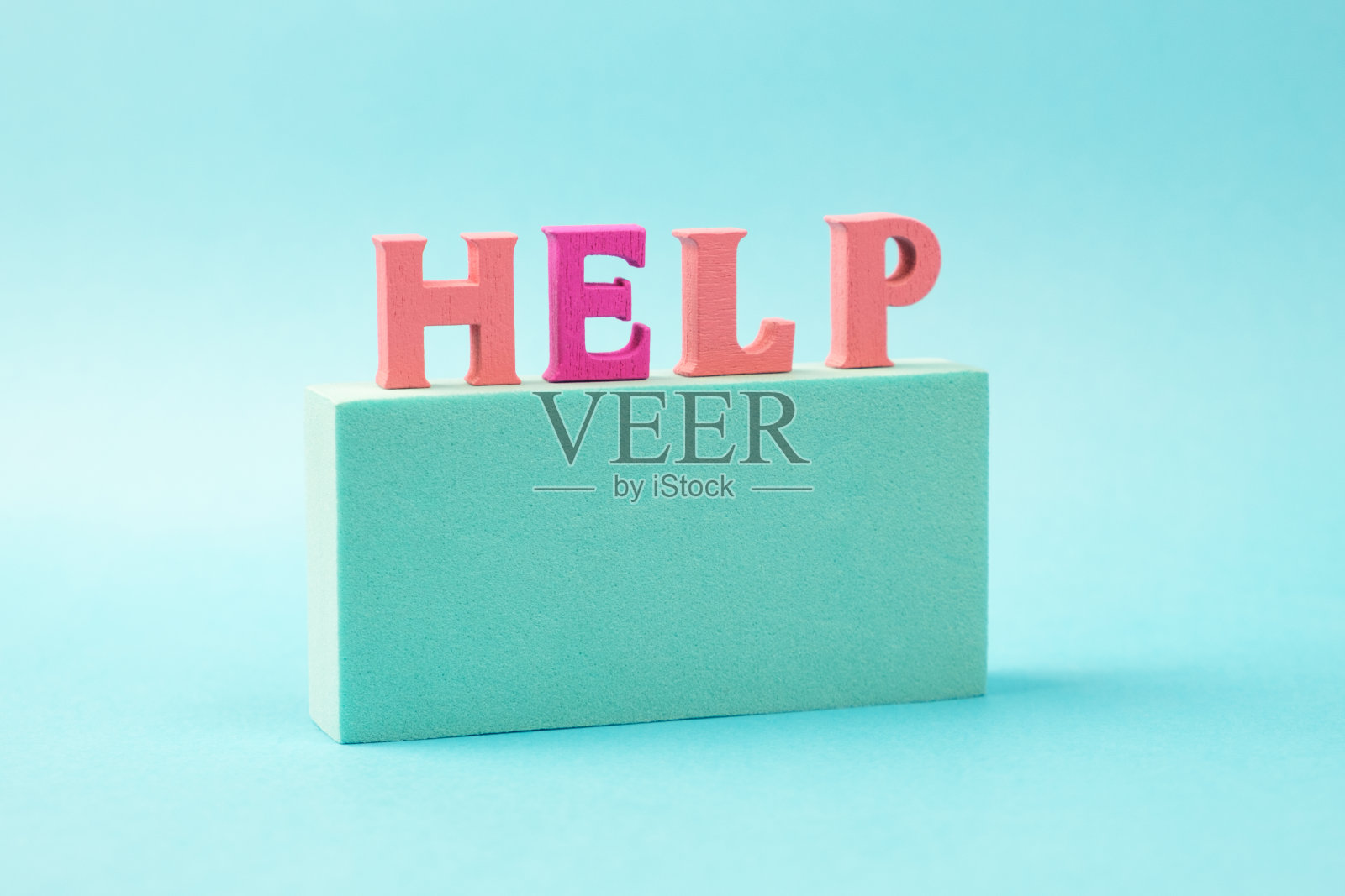 这个字帮助从木制明亮的字母在讲台上的浅蓝色的背景照片摄影图片