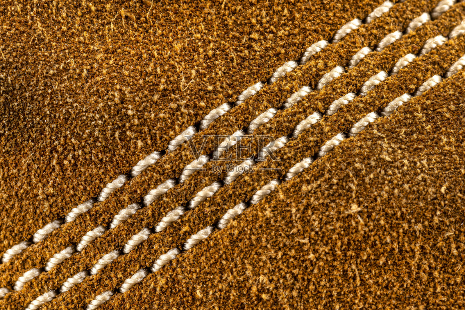 宏观背景制作棕色天然皮革与白色缝合在中心。照片摄影图片