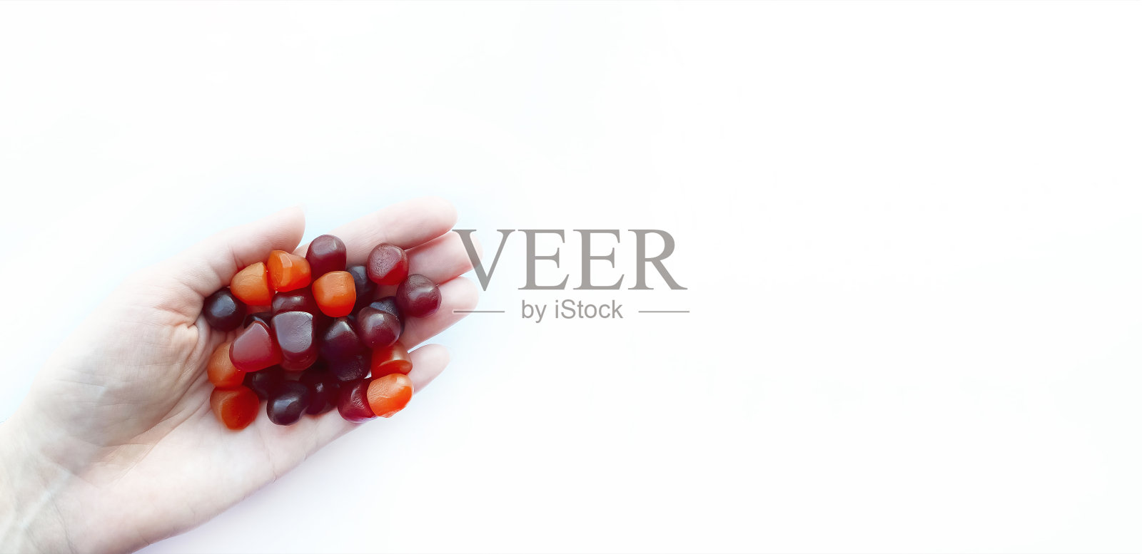 组红色、橙色和紫色的复合维生素软糖在白色的背景上分离照片摄影图片