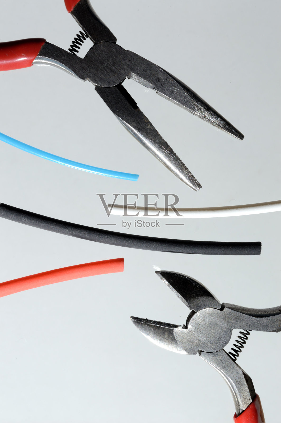 钢丝钳和热缩管。光背景的特写镜头。照片摄影图片