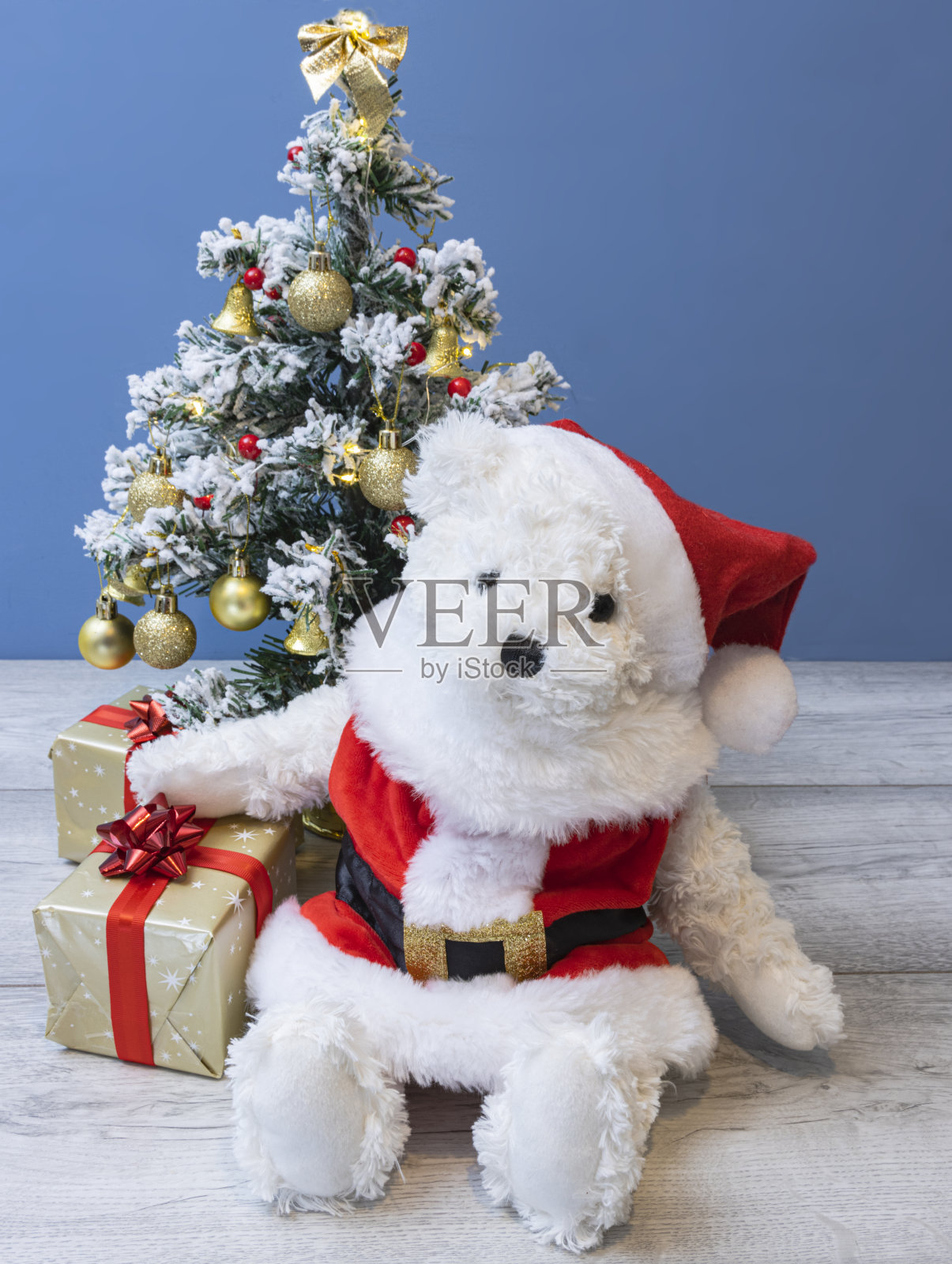 可爱的圣诞泰迪熊穿着圣诞老人的衣服，带着圣诞树和礼物照片摄影图片