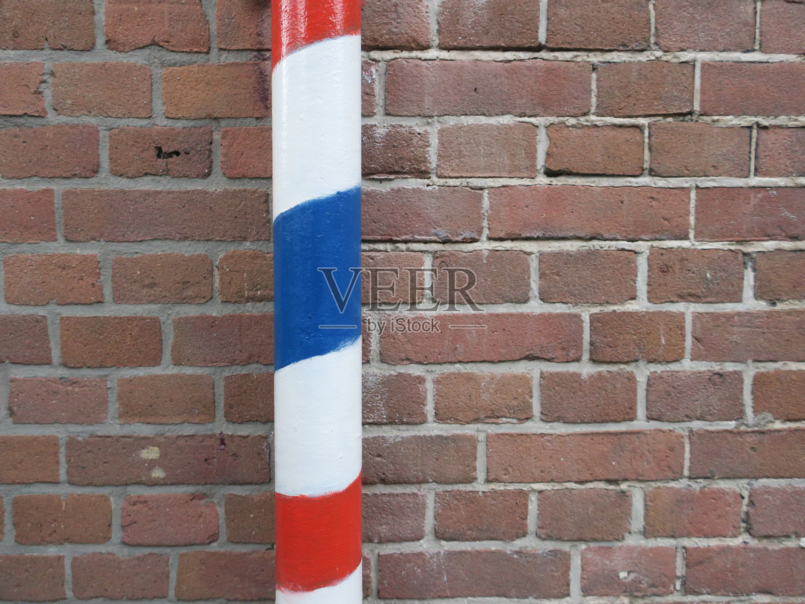 柱子被漆成红、白、蓝三色，作为理发店的标志照片摄影图片