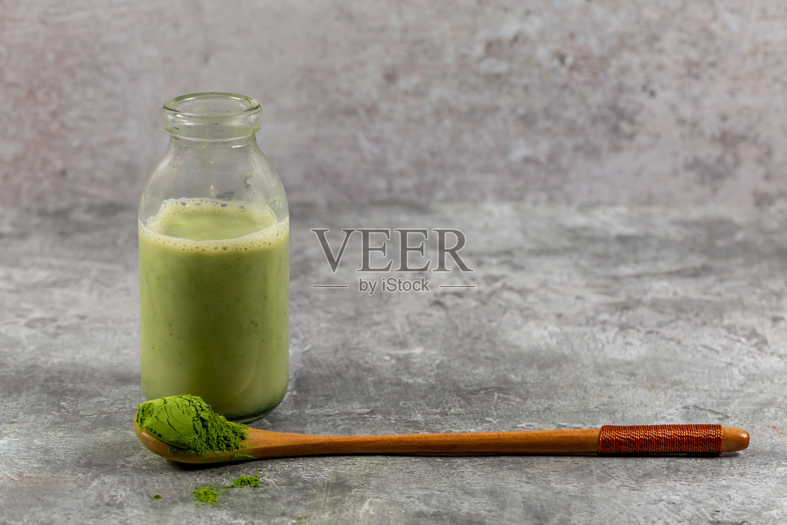 木勺上放抹茶绿茶粉，后面放抹茶拿铁照片摄影图片