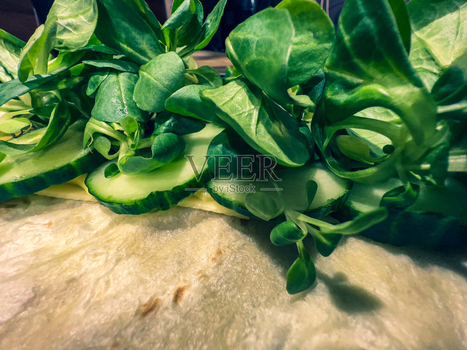 在薄面包上放蔬菜，奶酪和一点酱。照片摄影图片