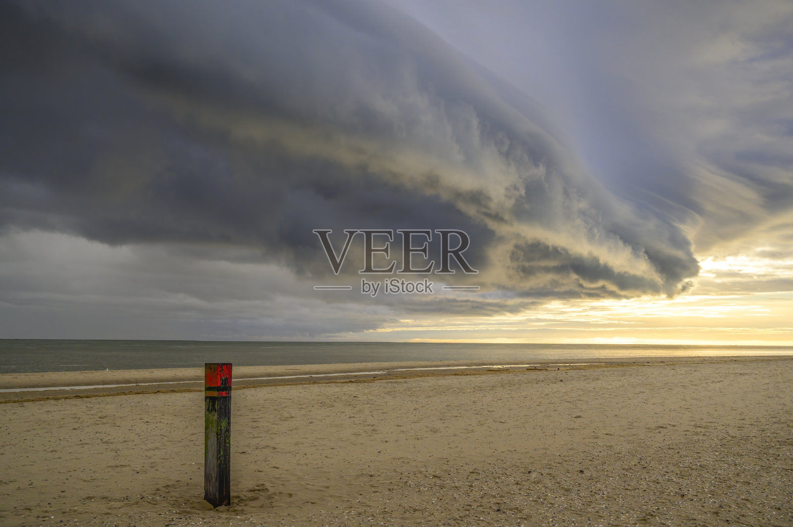 日出时，特塞尔岛海滩上的风暴云接近瓦登海照片摄影图片