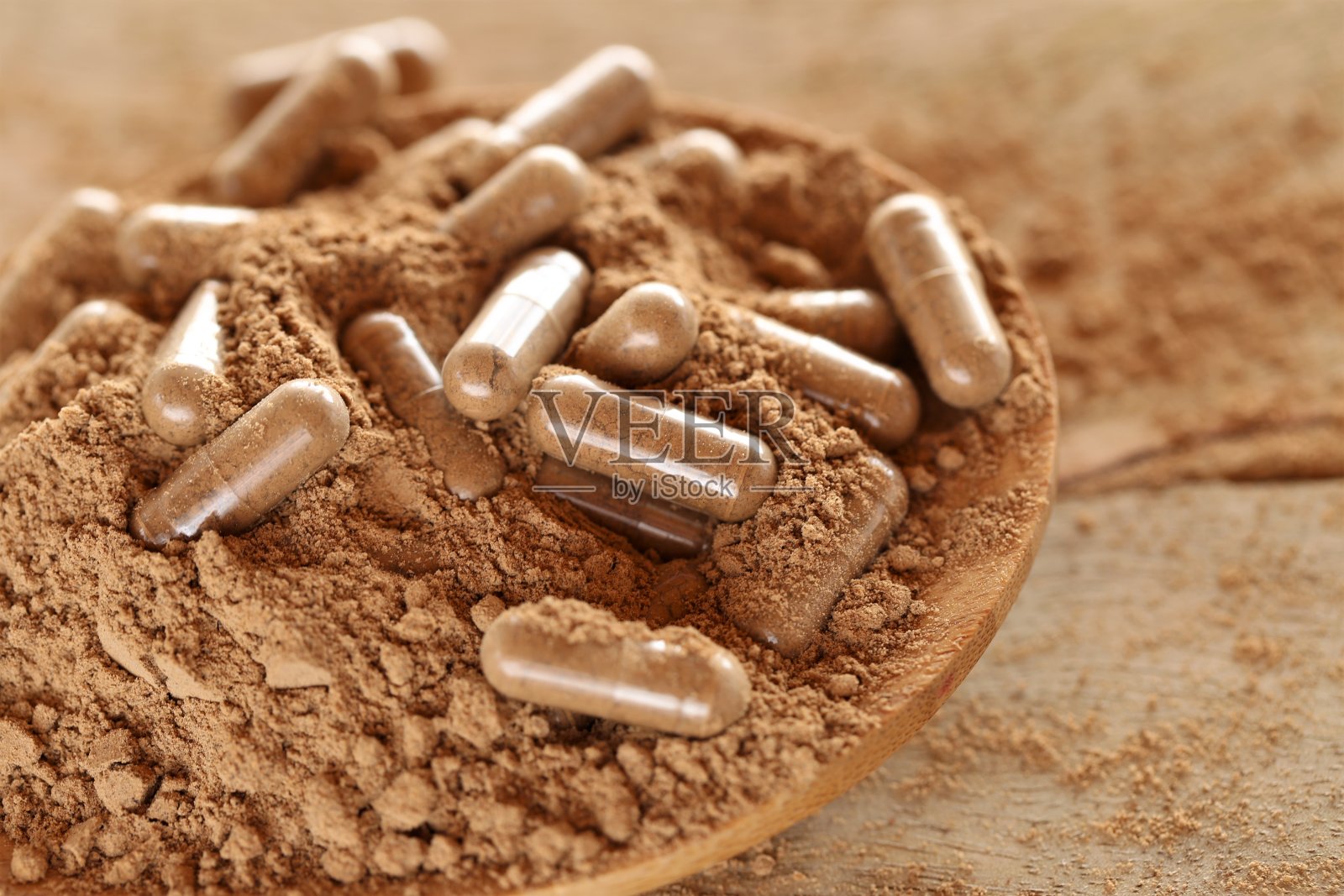 瓜拉那粉末中的瓜拉那胶囊。透明胶囊加瓜拉那粉。补充剂和维生素。健康饮食。运动营养。自然的补药。照片摄影图片