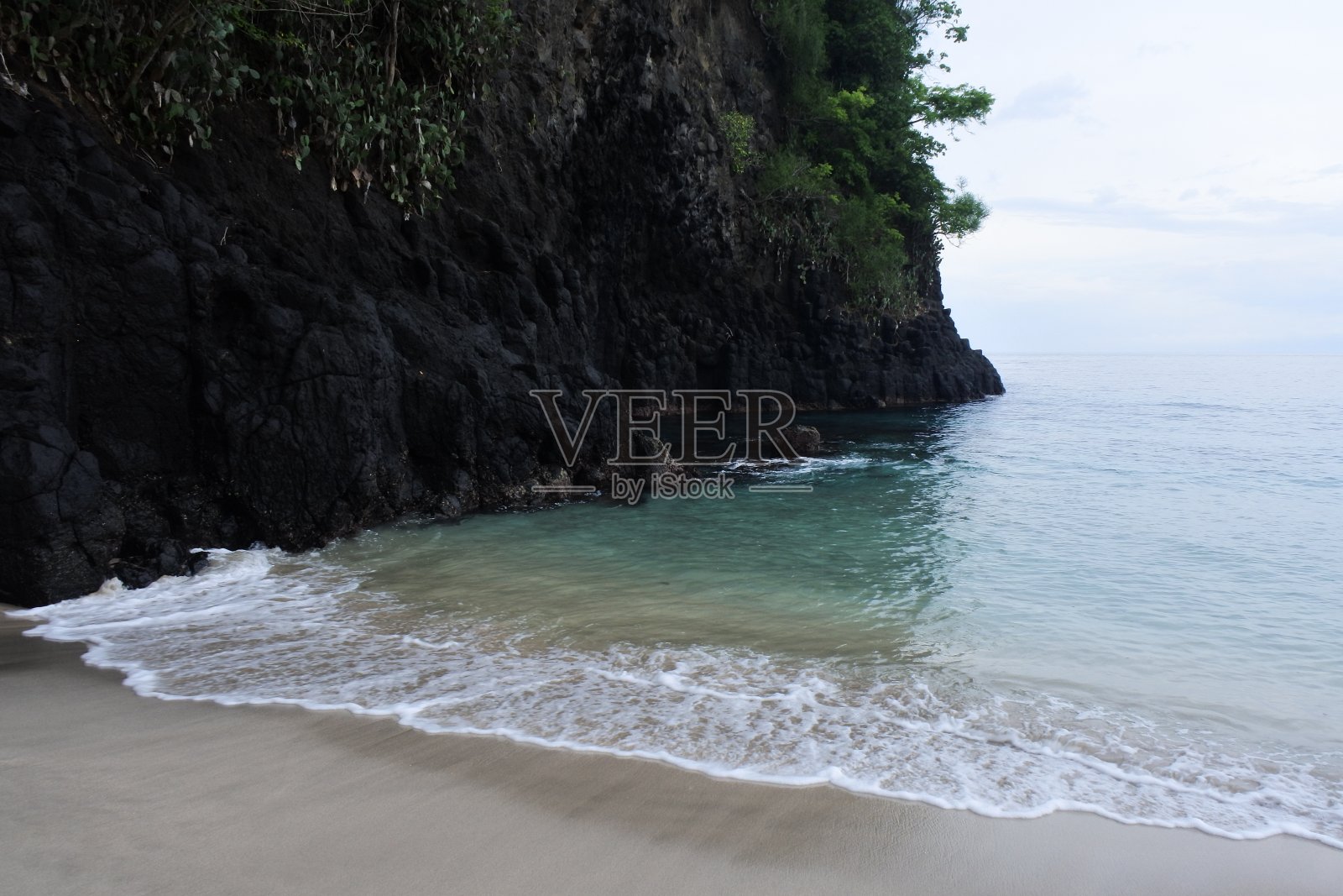 巴厘岛的Karangasem处女海滩。沿海植被。海浪和开阔的海洋以美丽的全景品味一个热带岛屿照片摄影图片