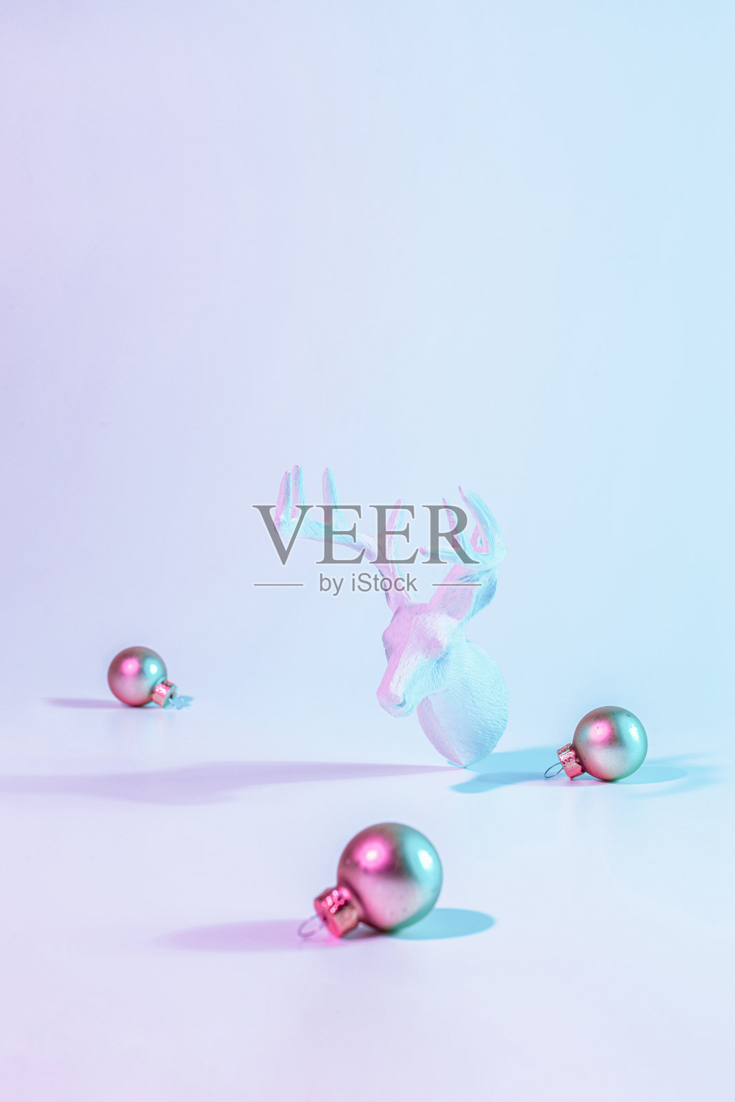 圣诞动物霓虹冬季背景。假日装饰球霓虹灯梯度背景。最小抽象的圣诞驯鹿。新年快乐复印空间。照片摄影图片