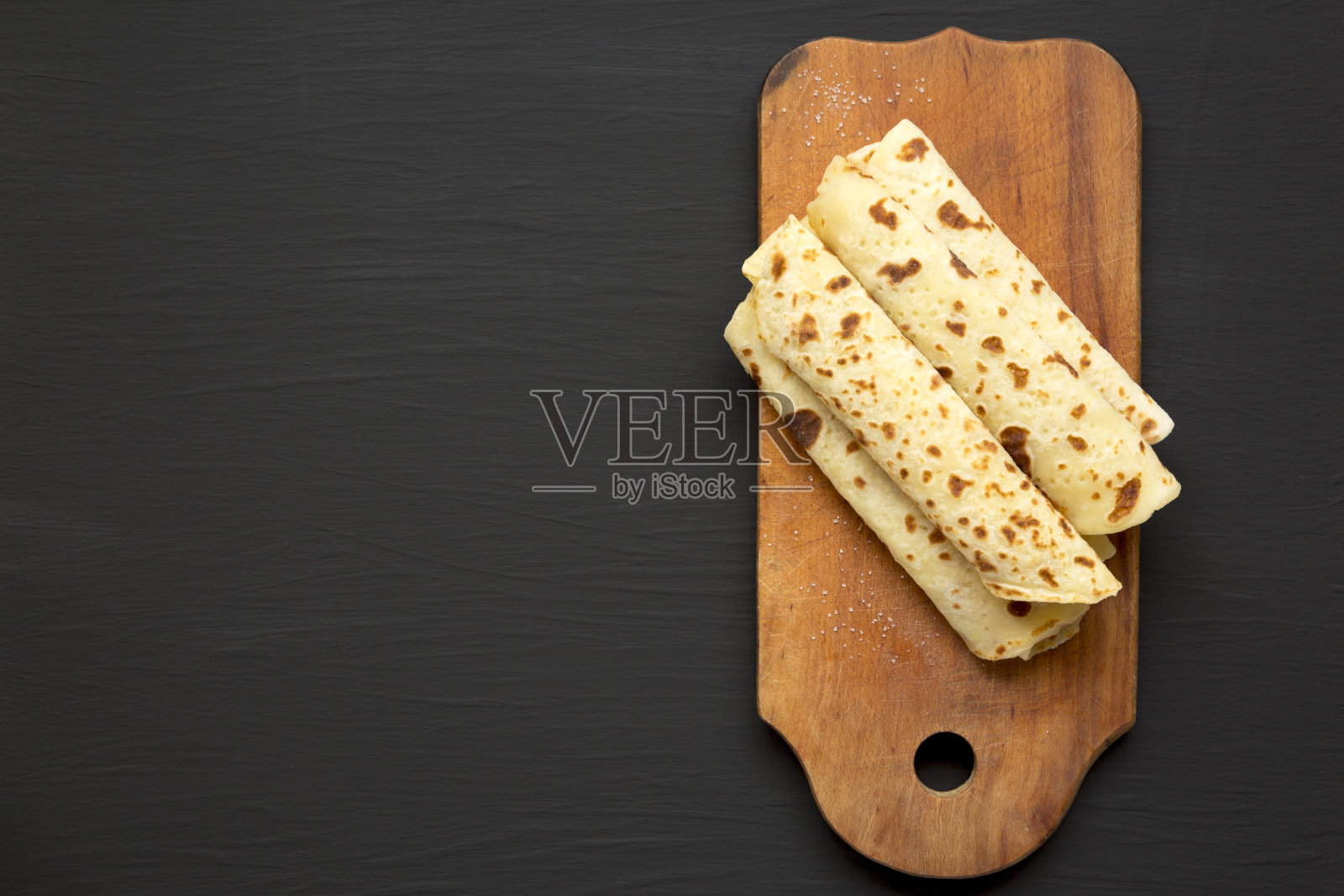 自制的挪威马铃薯饼(左)黄油和糖在一个黑色表面的乡村木板上，俯视图。开销,平。照片摄影图片