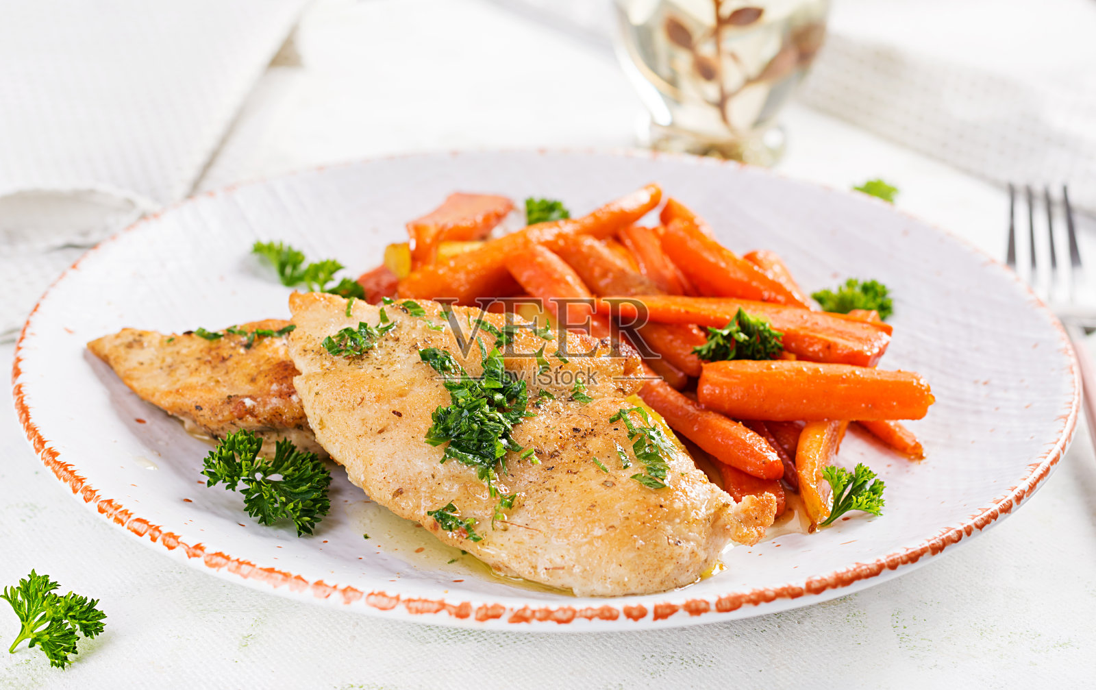 用焦糖胡萝卜装饰的炸鸡片。晚餐。照片摄影图片