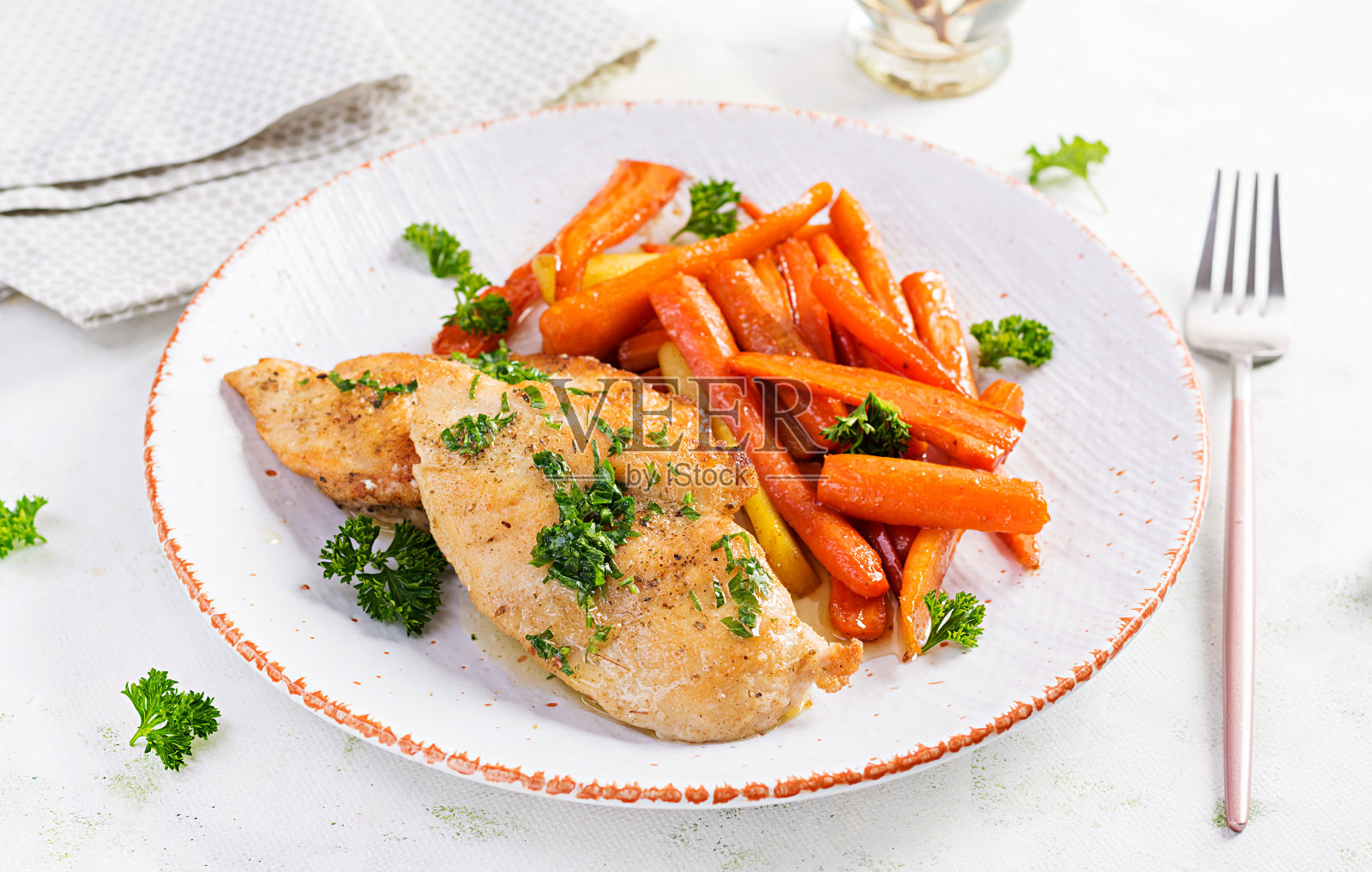 用焦糖胡萝卜装饰的炸鸡片。晚餐。照片摄影图片