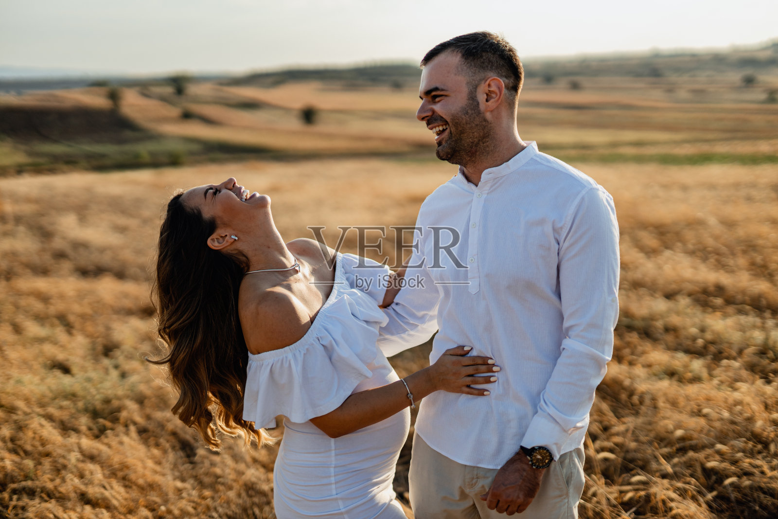 年轻的怀孕夫妇在享受大自然的一天照片摄影图片