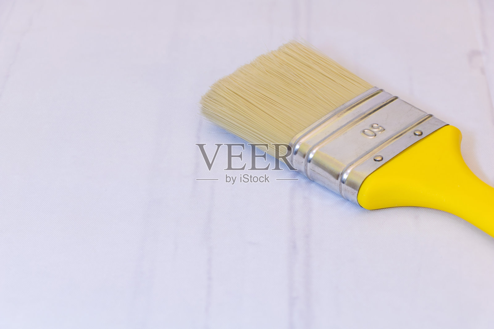一个新的带有黄色手柄的画笔，在灰色背景上有复制空间照片摄影图片