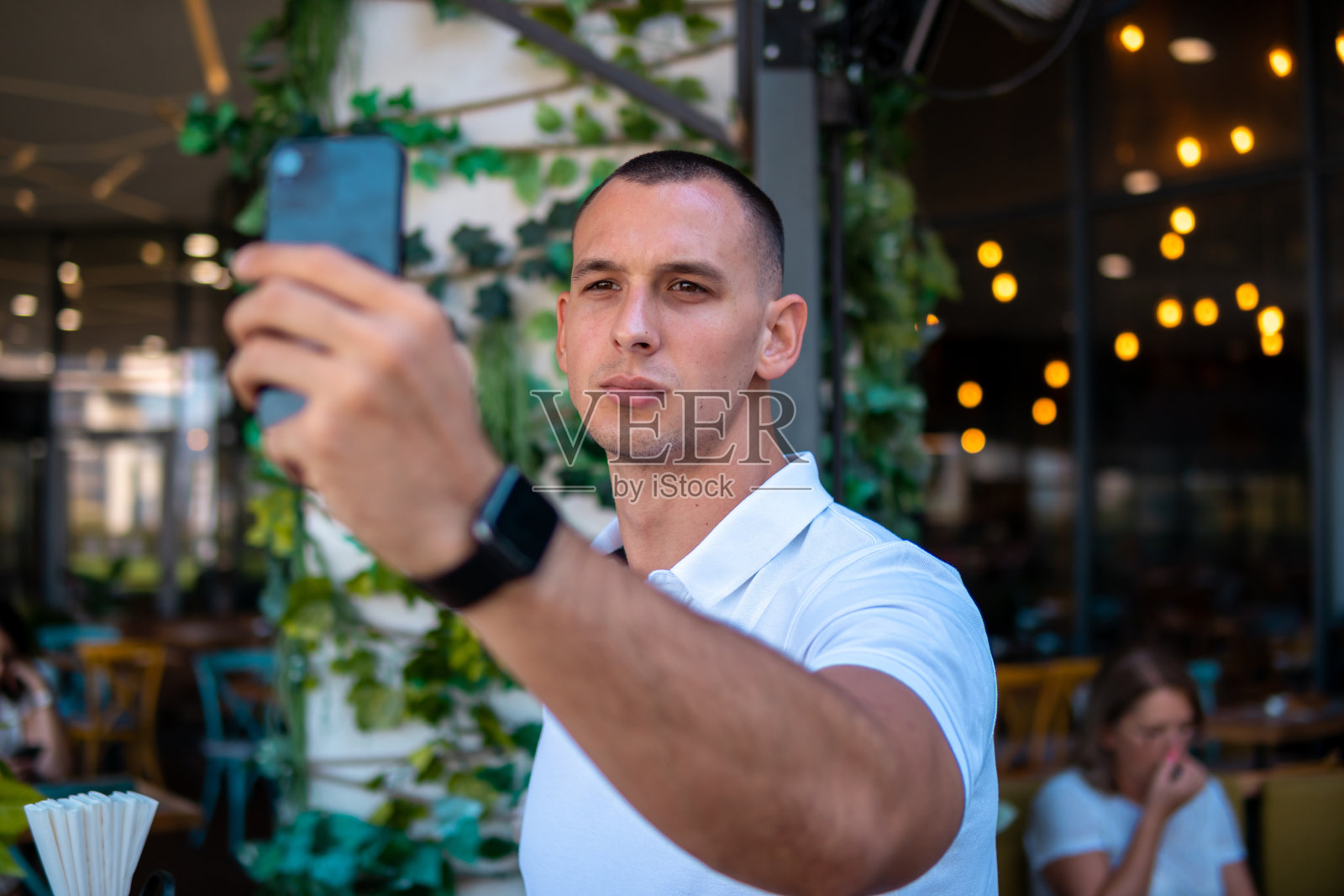 年轻英俊的商人工作在他的笔记本电脑，而坐在咖啡馆照片摄影图片