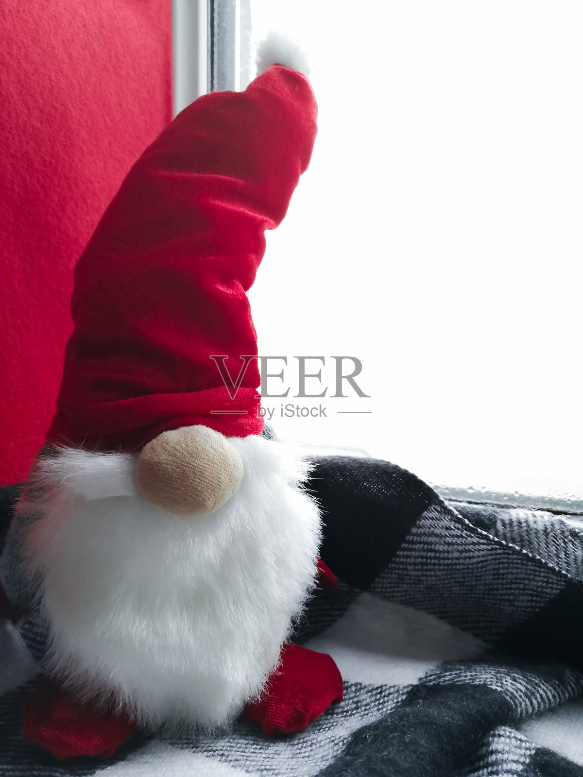 圣诞侏儒站在窗台上。照片摄影图片