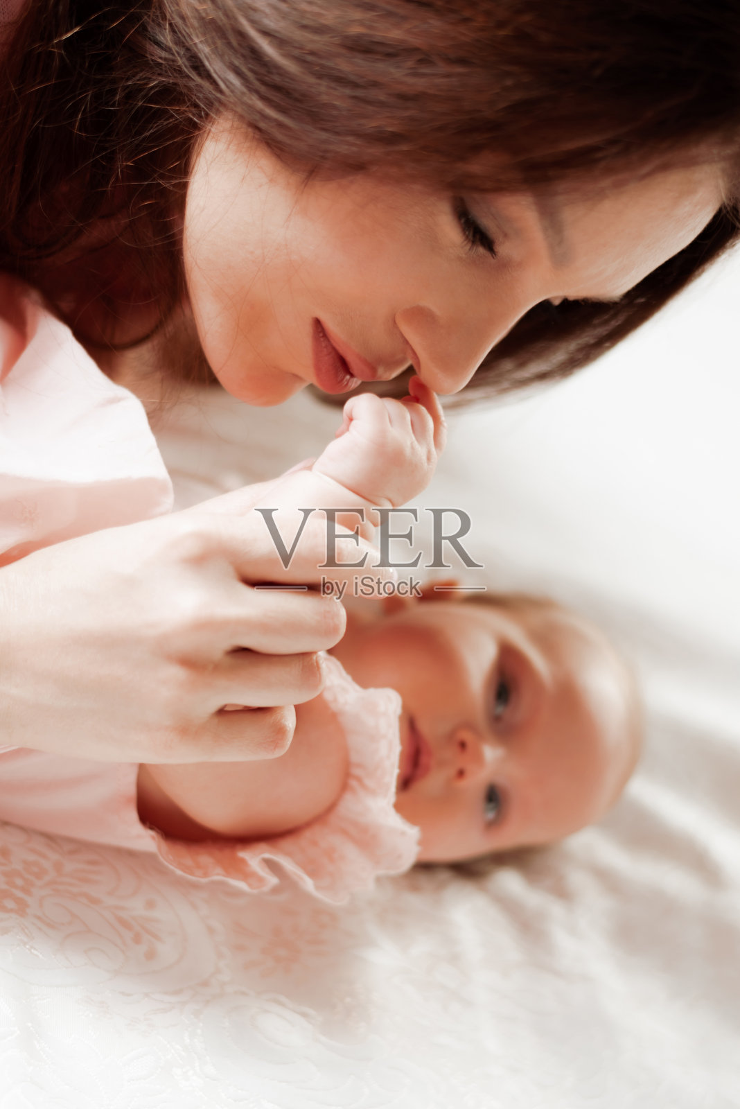 美丽的母亲亲吻着她的小女儿照片摄影图片