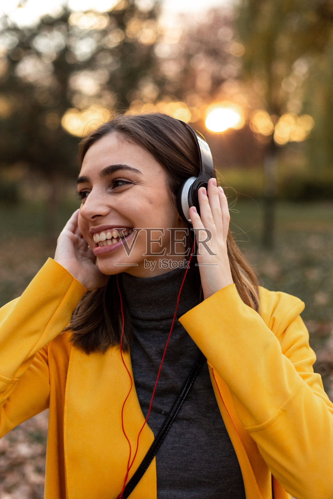 在公园里听音乐的女孩。照片摄影图片