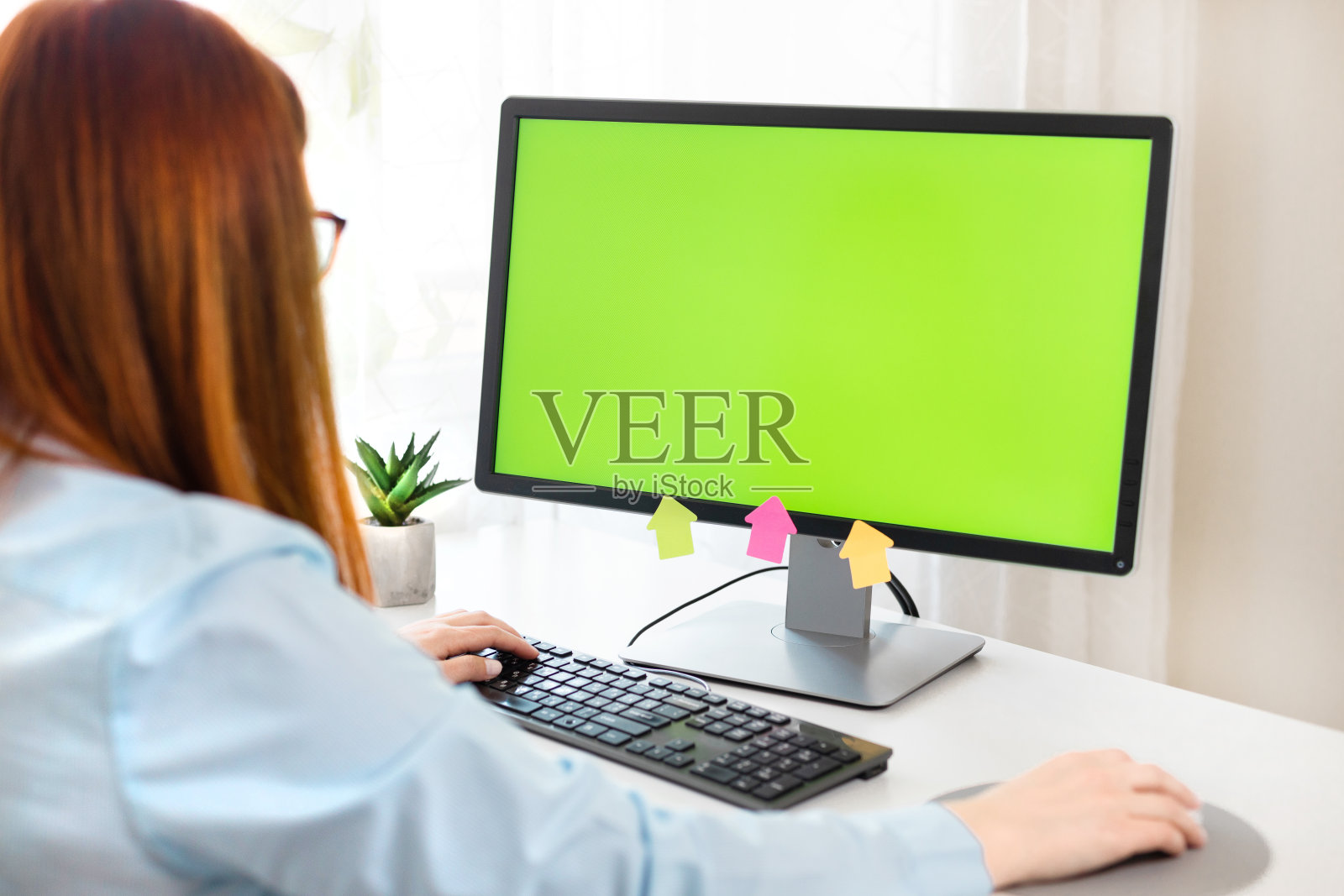 近女性的手和电脑与绿色chromakey黑屏。电脑显示器的模型照片摄影图片