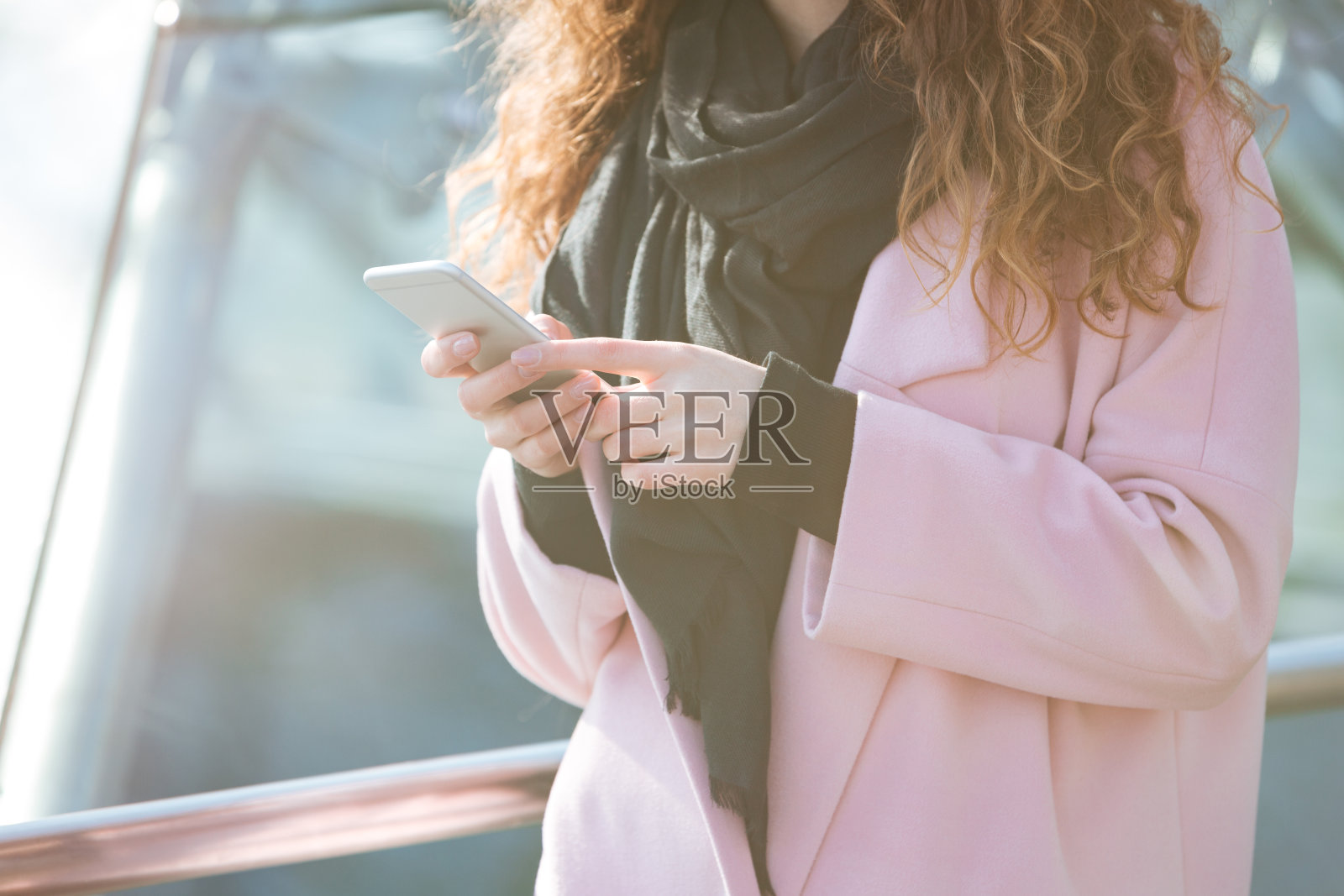 一个女人在街上用手机的特写镜头。照片摄影图片