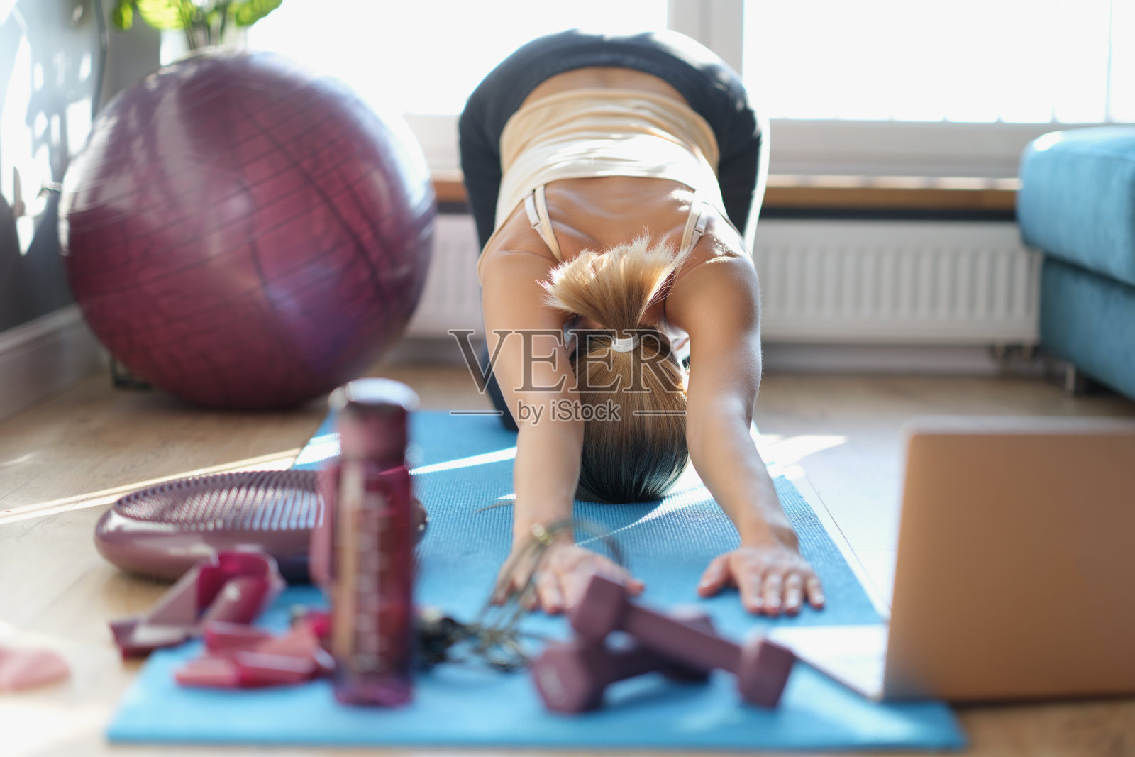 一个苗条的女人正在地板上做伸展运动照片摄影图片