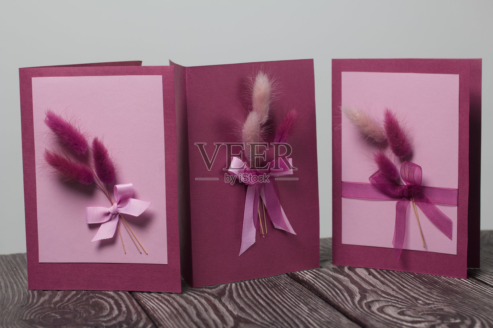 制作贺卡。纸空白，丝带和拉格鲁树枝。它们躺在黑松木板上。照片摄影图片