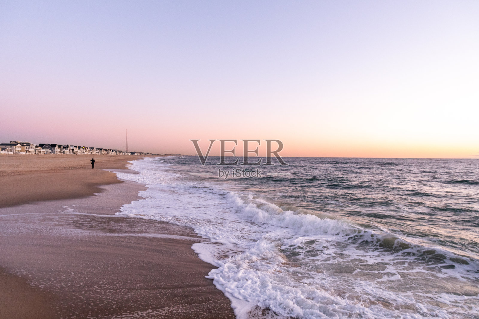 日出时海浪拍打着海滩照片摄影图片