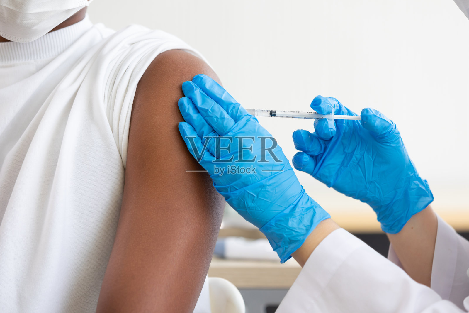 特写医生手持注射器向患者注射疫苗，covid-19疫苗概念照片摄影图片