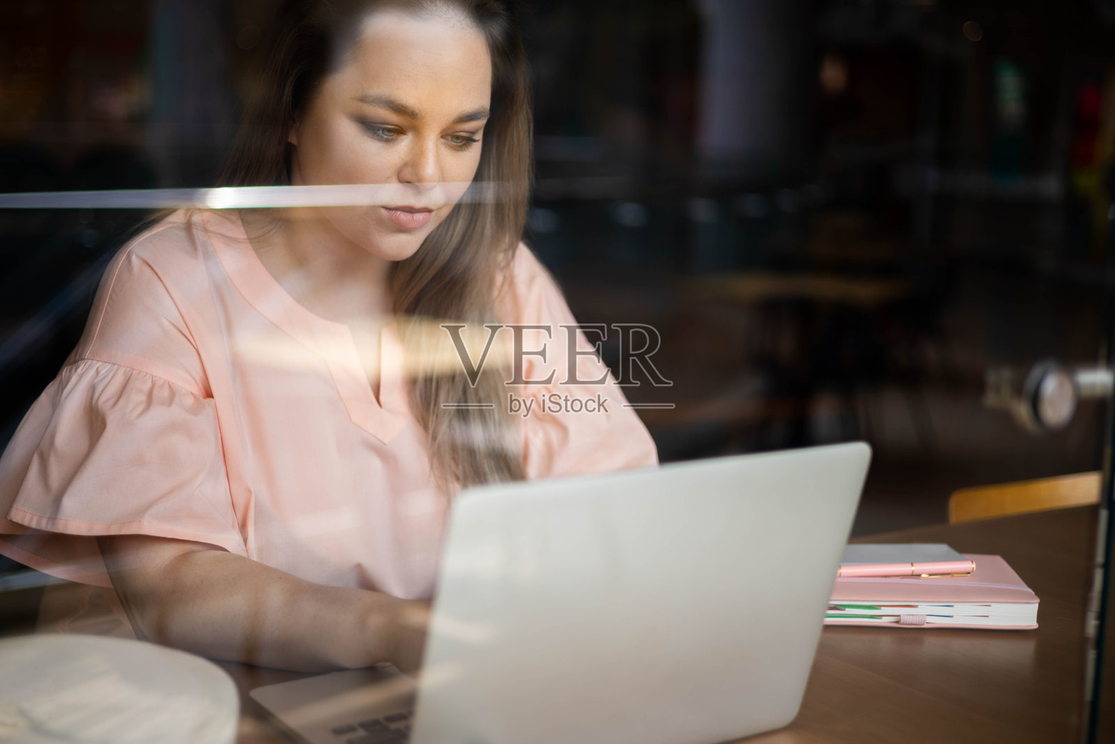 快乐加大小的商业妇女工作在咖啡馆使用笔记本电脑聊天，上网照片摄影图片
