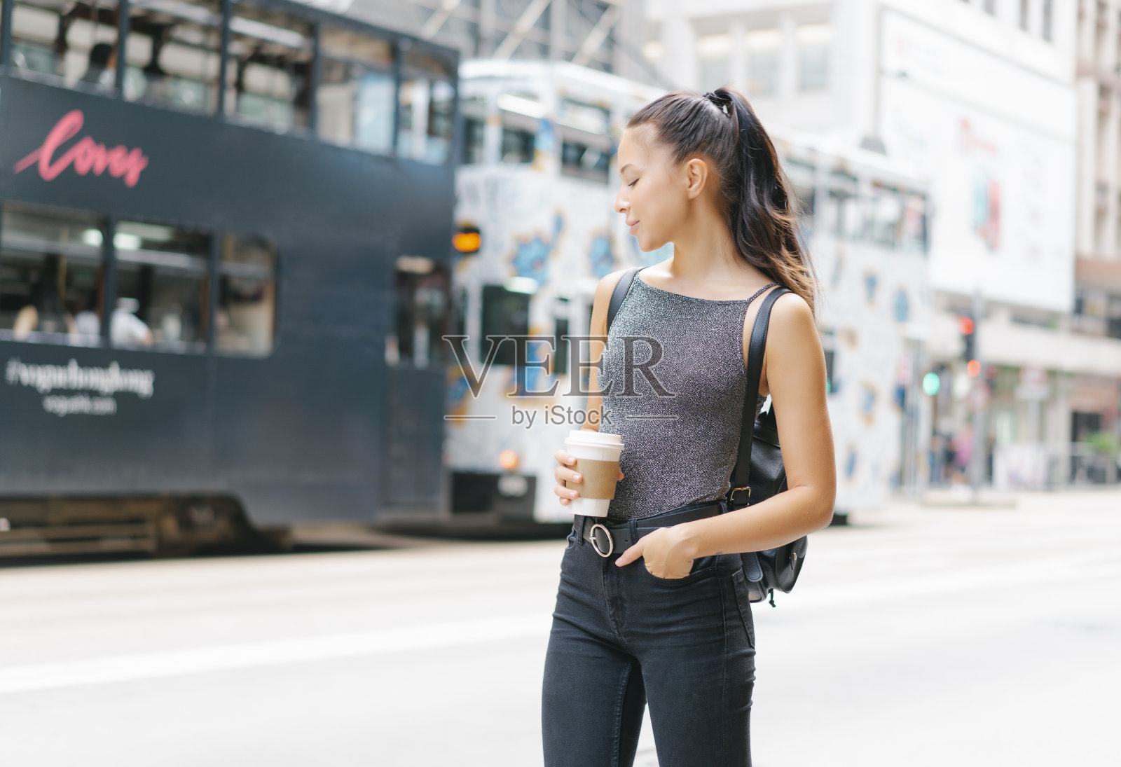 肖像美丽的女人拿着咖啡杯的热饮，享受在城市里散步，微笑享受周末，背包旅行。照片摄影图片