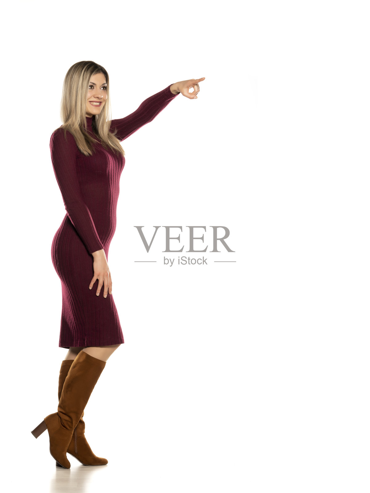 年轻漂亮的金发女郎穿着红色紧身连衣裙和皮靴照片摄影图片