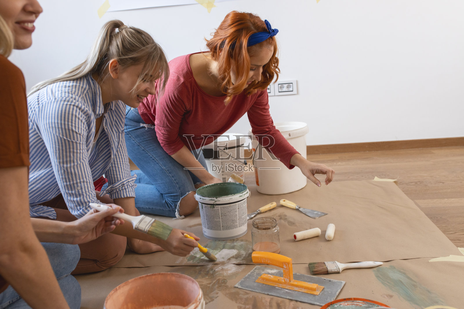 女性朋友正在准备和混合油漆来装饰家里的墙壁。照片摄影图片