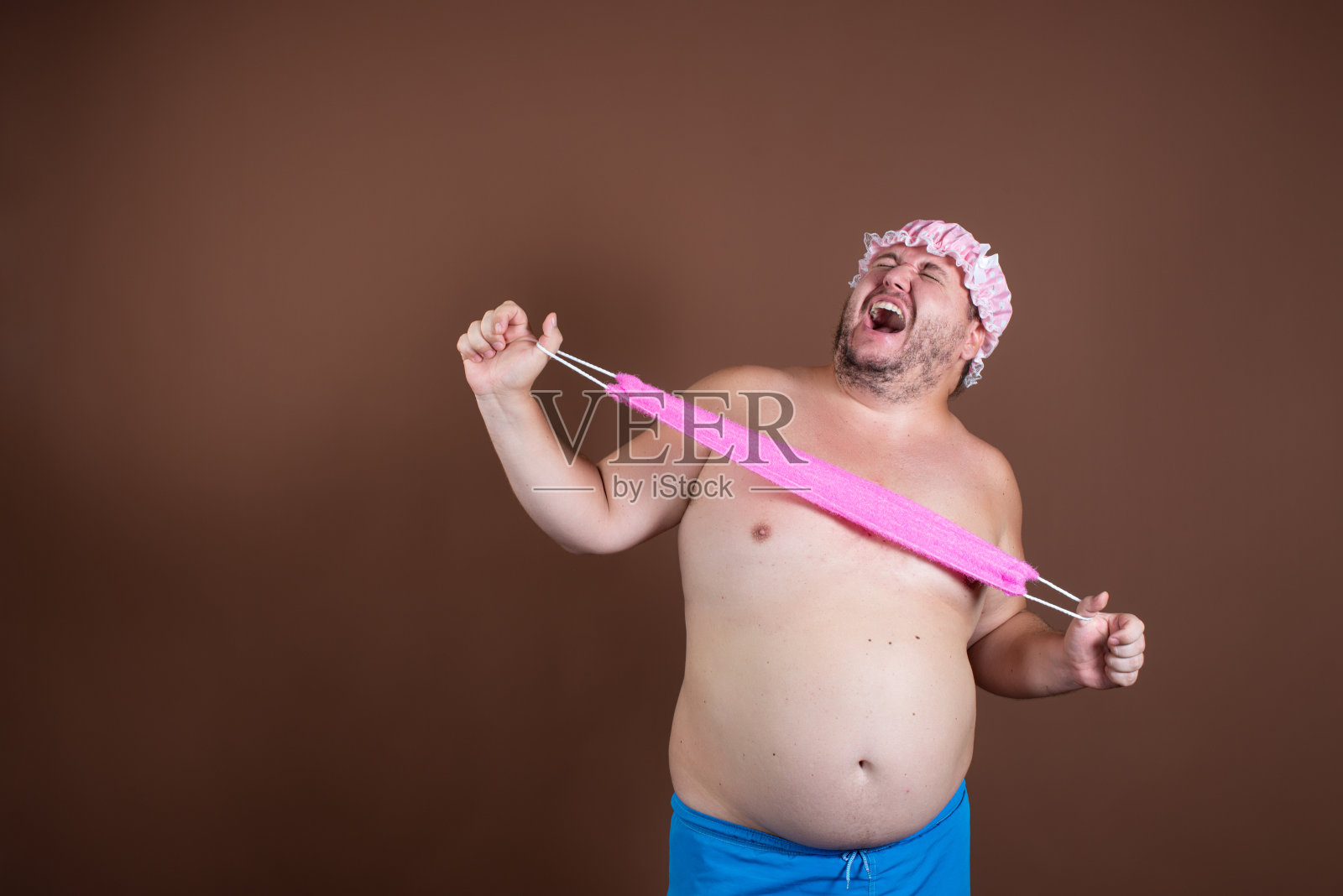 桑拿室。有趣的胖子。棕色的背景。照片摄影图片