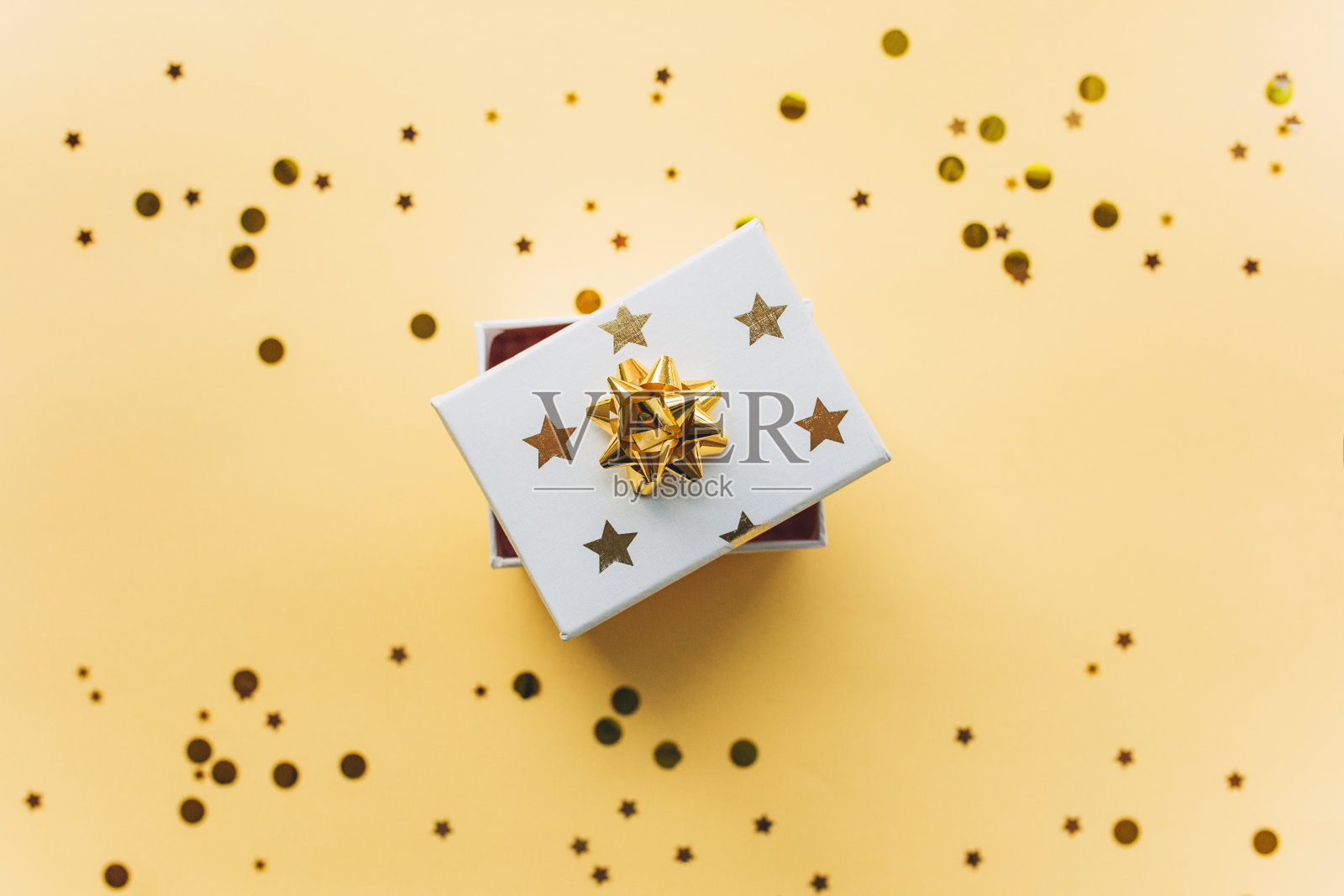 打开礼品白色盒与金箔和五彩纸屑在一个金色的背景。庆祝圣诞节或新年或获奖或升职或其他节日概念。平铺，俯视图照片摄影图片