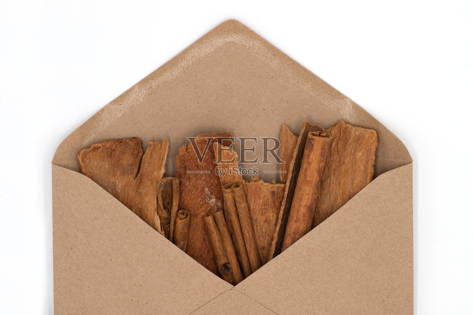 肉桂棒和香料树皮在工艺信封白色的背景照片摄影图片
