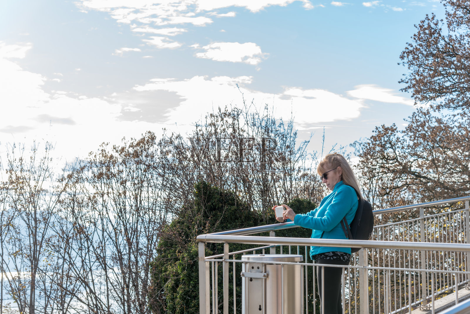 一位戴着墨镜的金发女子从瑞士佩林山的视角拍摄日内瓦湖。照片摄影图片