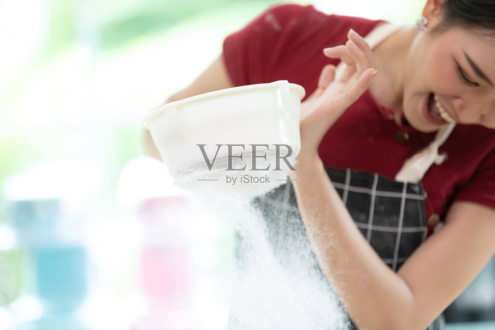 年轻的家庭妇女在厨房用筛子筛面粉照片摄影图片