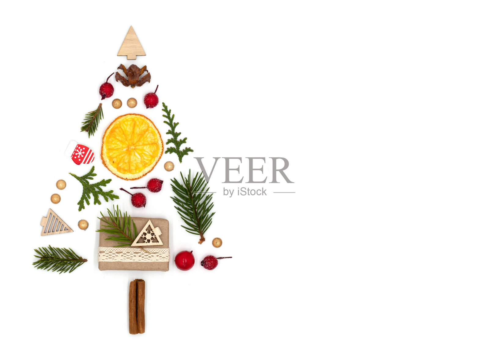 抽象的节日构成形式的圣诞树由玩具和杉木枝、红莓和肉桂枝组成，在白色背景上有干净的空间，顶视图平铺照片摄影图片