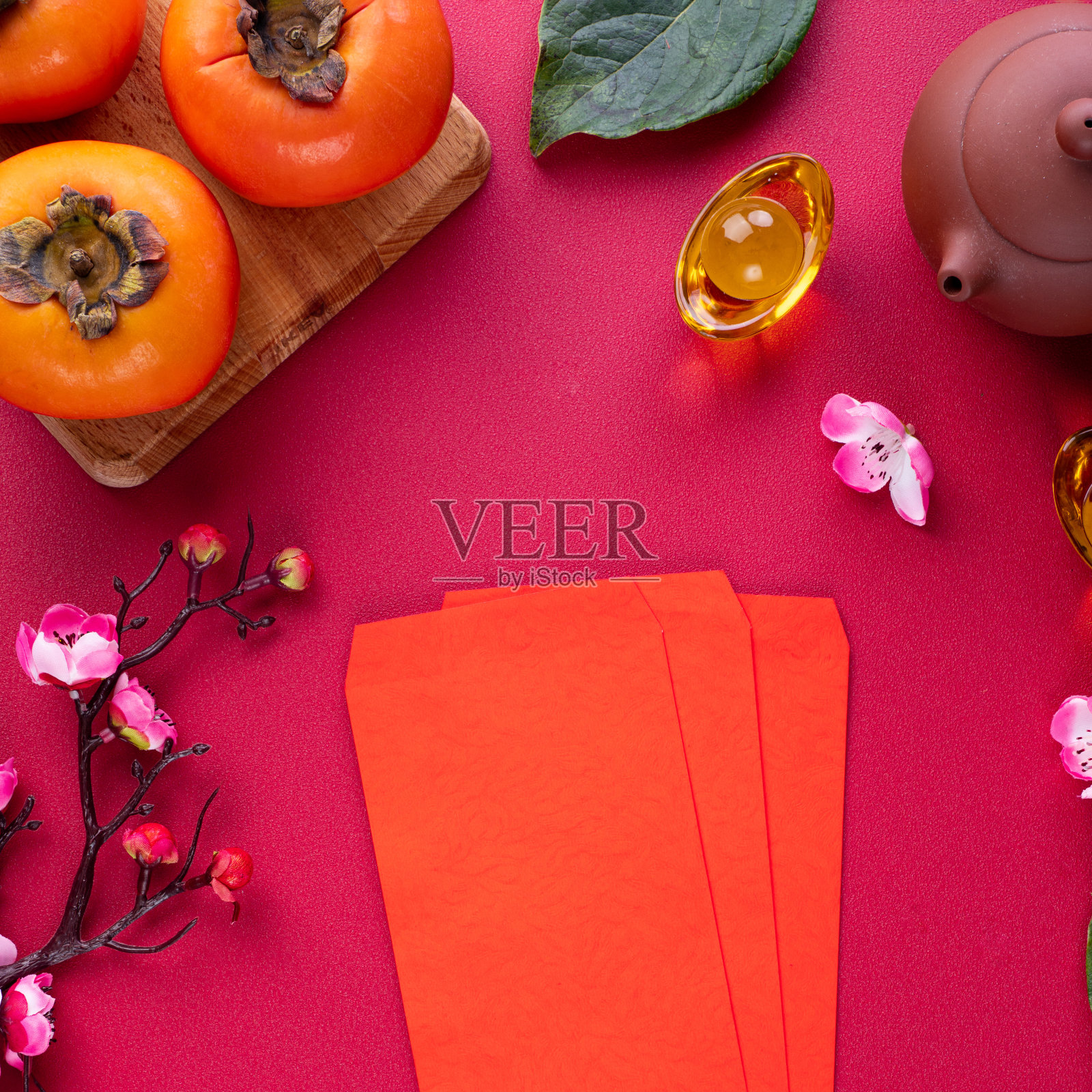 新鲜的甜柿子和叶子在红色的桌子背景为中国农历新年的俯视图照片摄影图片