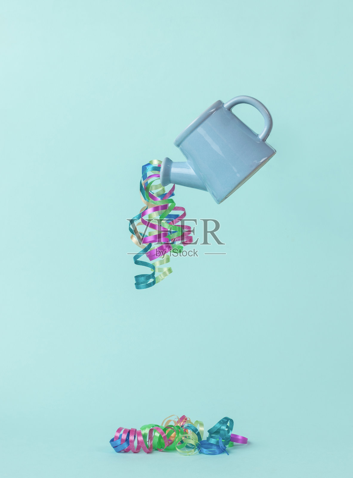 一个蓝色喷壶，在浅蓝色的背景上有一条蛇从喷壶中流出。新年的最小概念。当代艺术。照片摄影图片