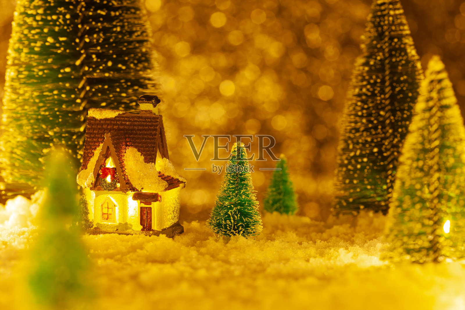 圣诞贺卡。雪中的小玩具屋。人工云杉照片摄影图片